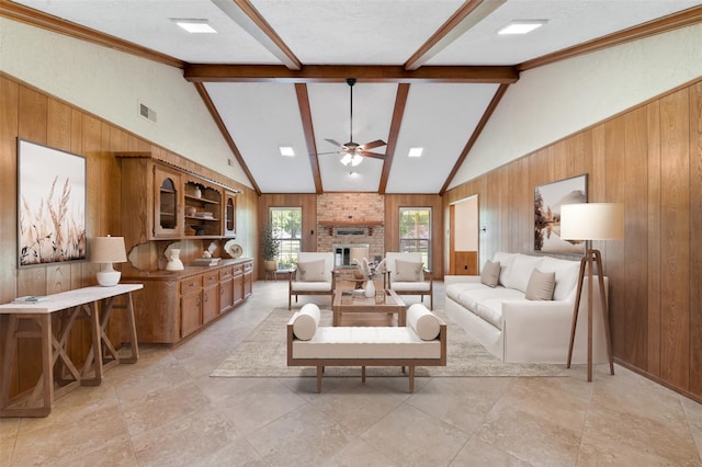 living room featuring a fireplace, beam ceiling, a textured ceiling, and wood walls