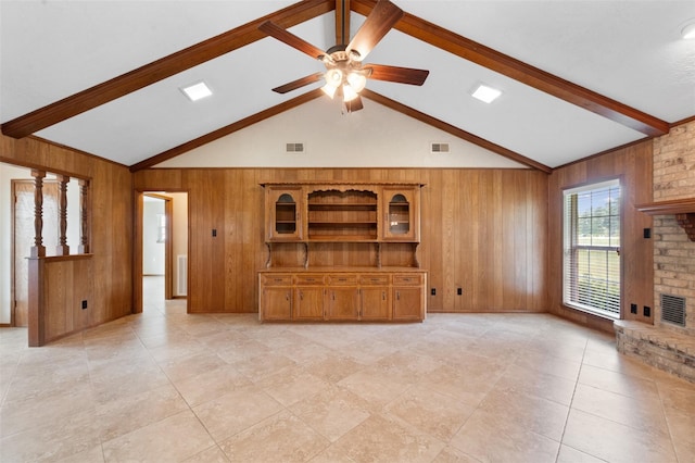 unfurnished living room featuring wood walls, ceiling fan, high vaulted ceiling, and a brick fireplace