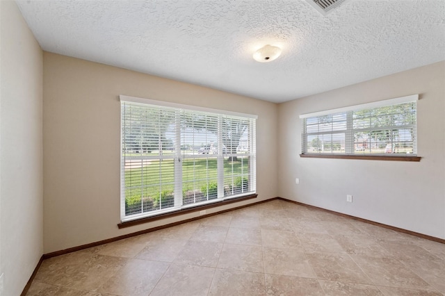 tiled spare room with a textured ceiling