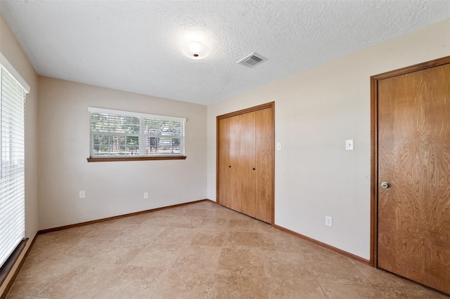 unfurnished bedroom featuring a closet and a textured ceiling