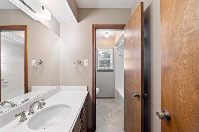 full bathroom featuring tiled shower / bath combo, tile patterned floors, a textured ceiling, toilet, and vanity