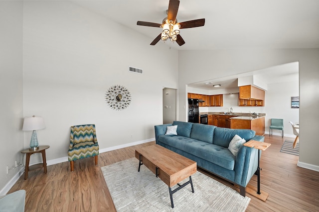 living room with light wood-style flooring, baseboards, a ceiling fan, and visible vents