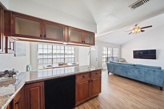 kitchen featuring ceiling fan, light wood-style flooring, vaulted ceiling, visible vents, and black dishwasher