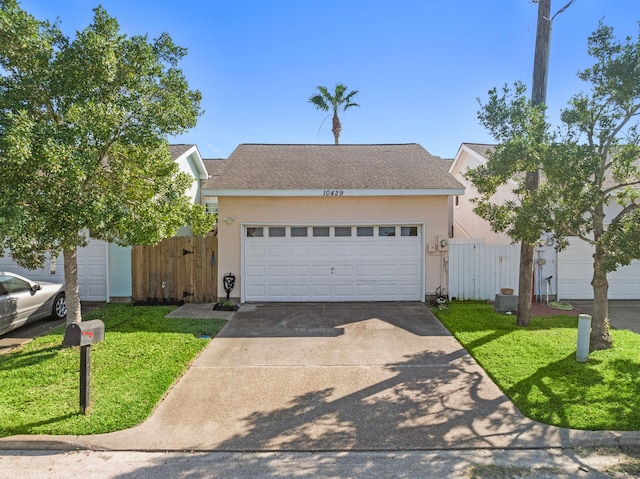 view of front of house with roof with shingles, driveway, stucco siding, and a gate