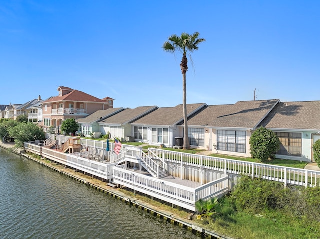 back of property featuring a residential view, a deck with water view, and fence