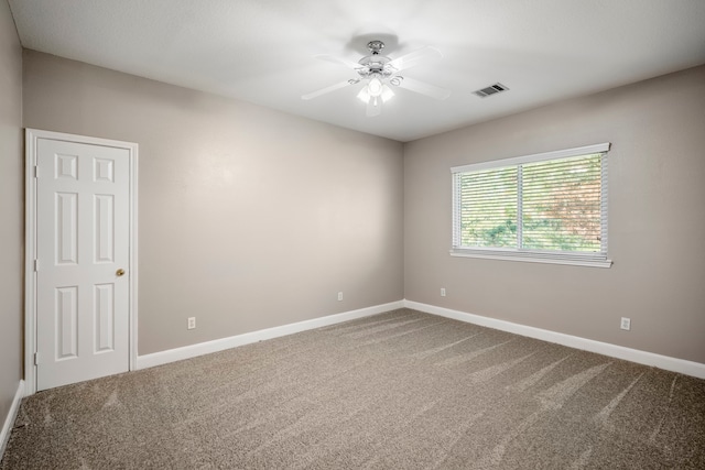 carpeted spare room featuring ceiling fan