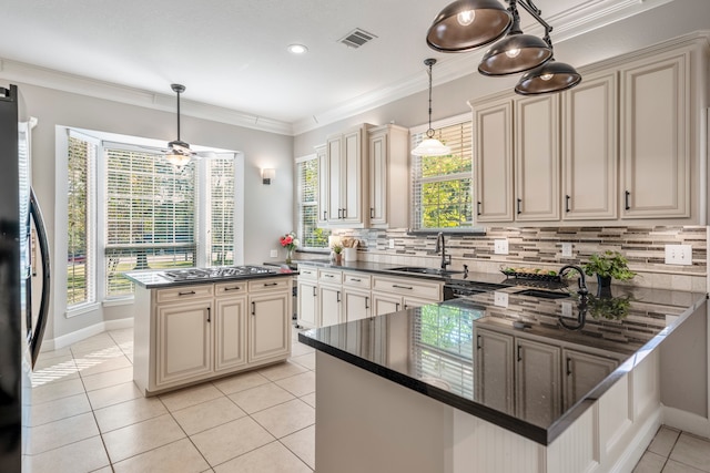 kitchen with cream cabinets, refrigerator, and sink