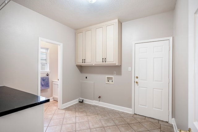 clothes washing area with cabinets, washer hookup, hookup for an electric dryer, gas dryer hookup, and a textured ceiling