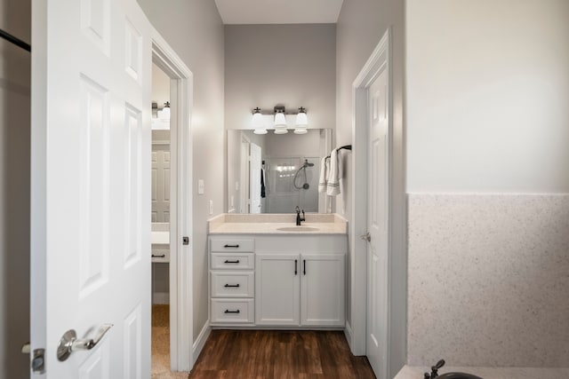 bathroom with hardwood / wood-style flooring, vanity, and walk in shower