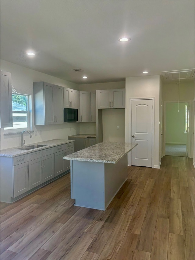 kitchen featuring a center island, light hardwood / wood-style flooring, and sink