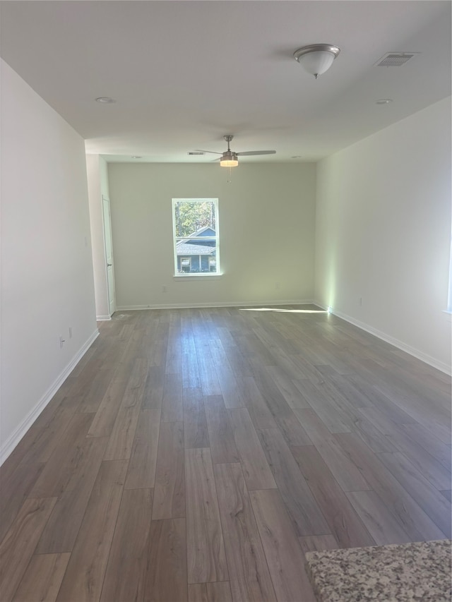 empty room with hardwood / wood-style floors and ceiling fan