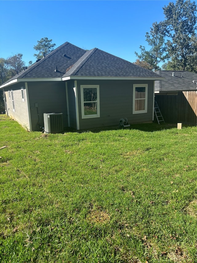 back of house with a lawn and central AC