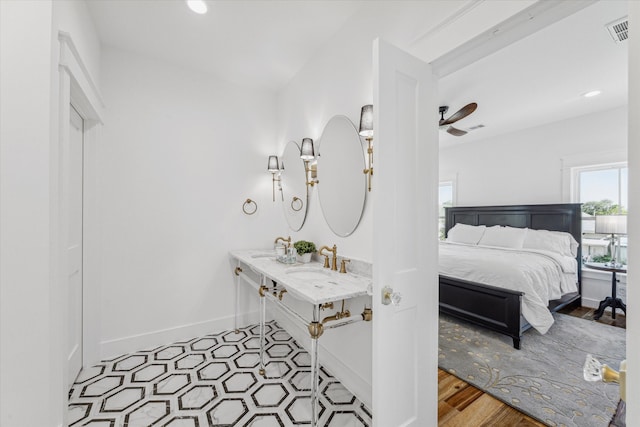 bathroom with hardwood / wood-style flooring, ceiling fan, and sink