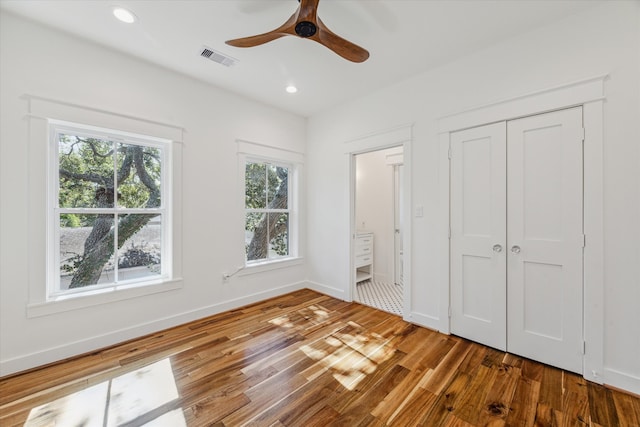 unfurnished bedroom with ceiling fan and dark wood-type flooring