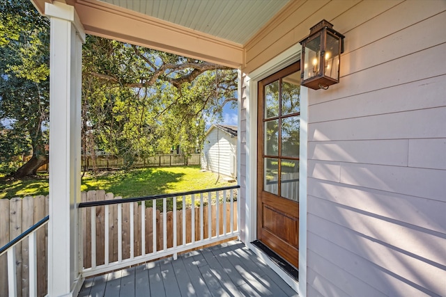 view of exterior entry with a yard and a porch