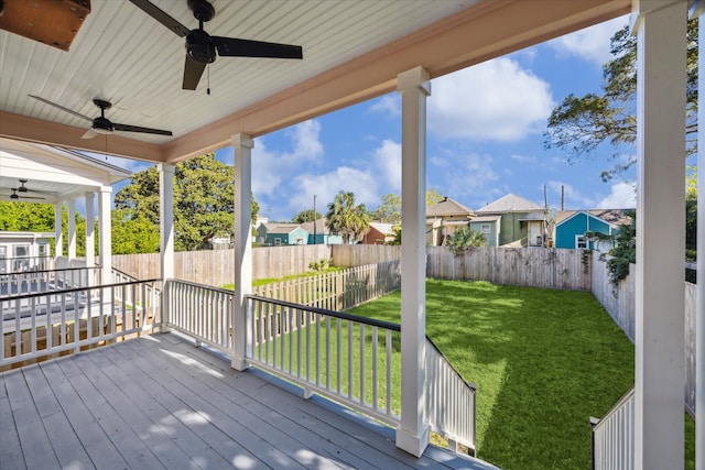 wooden deck with ceiling fan and a yard