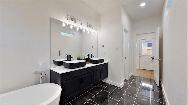 bathroom with plenty of natural light, a bath, and vanity