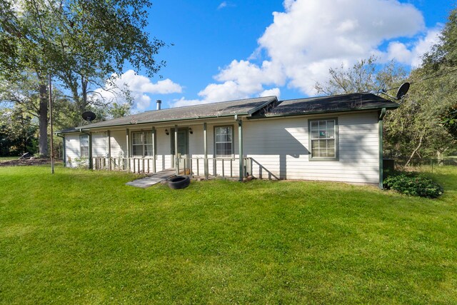 rear view of property with a lawn and a porch