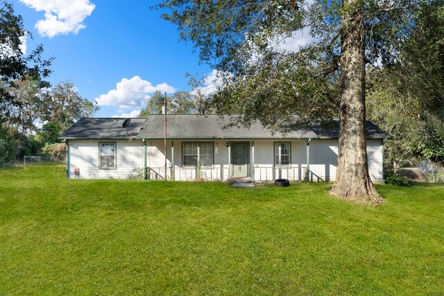 rear view of property featuring a lawn