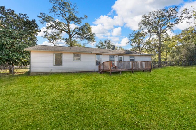 rear view of property featuring a lawn and a wooden deck