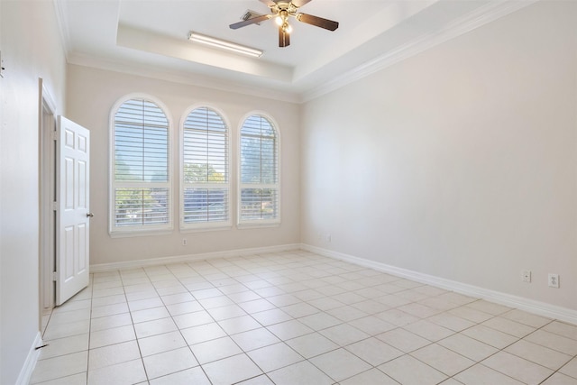 tiled empty room with a tray ceiling, ceiling fan, and crown molding