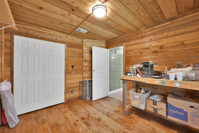 office featuring light hardwood / wood-style flooring, wooden walls, and wood ceiling