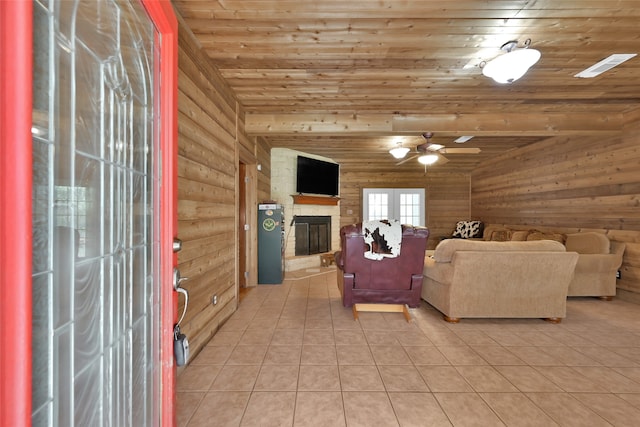 living room featuring ceiling fan, light tile patterned flooring, wooden ceiling, and a fireplace