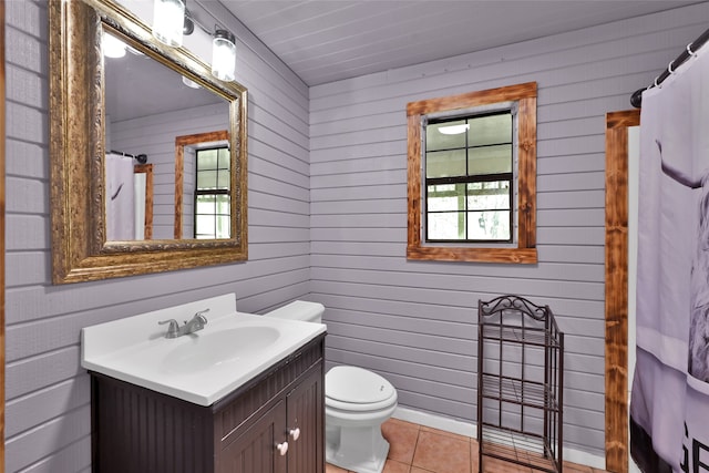 bathroom with tile patterned floors, vanity, and wooden walls