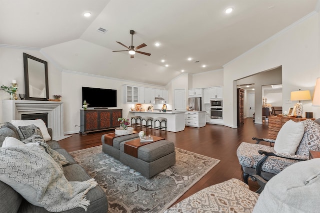 living room featuring dark hardwood / wood-style floors, ornamental molding, and vaulted ceiling