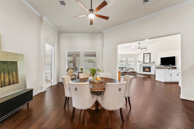 dining space with crown molding, dark hardwood / wood-style flooring, and ceiling fan