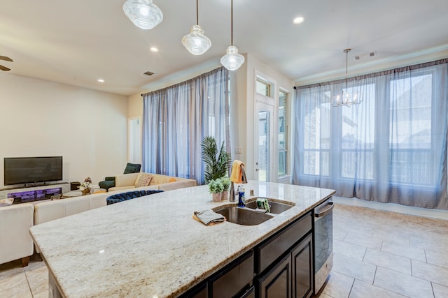 kitchen with pendant lighting, dishwasher, light stone countertops, and sink