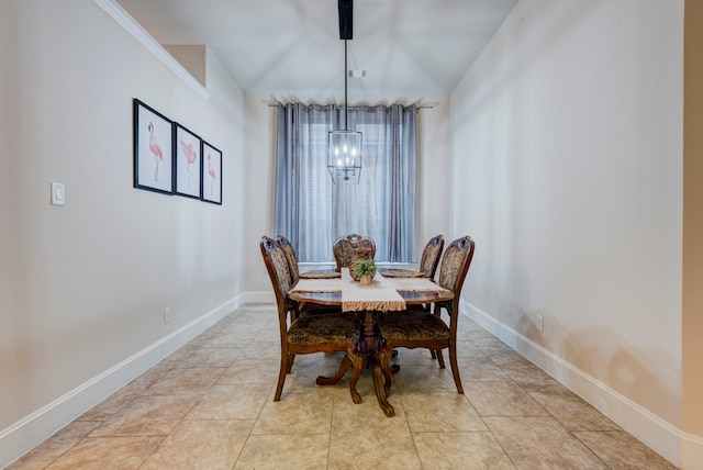 tiled dining room with a chandelier