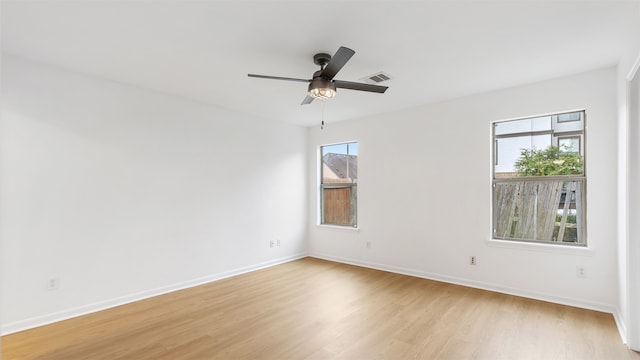 spare room with a wealth of natural light, light hardwood / wood-style flooring, and ceiling fan