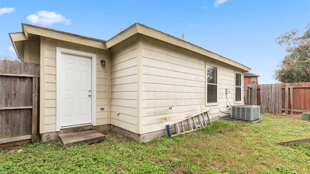 view of side of home with a yard and central AC unit