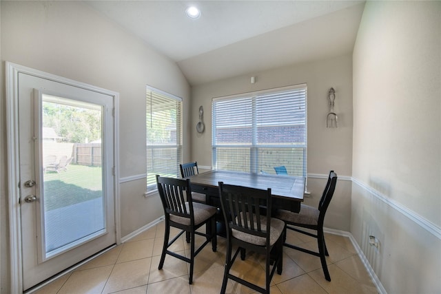 dining room featuring vaulted ceiling and light tile patterned floors