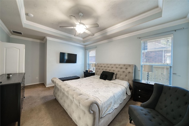 carpeted bedroom featuring ceiling fan, ornamental molding, and a tray ceiling