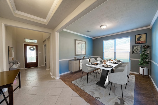 dining area featuring a textured ceiling, ornamental molding, and light tile patterned floors