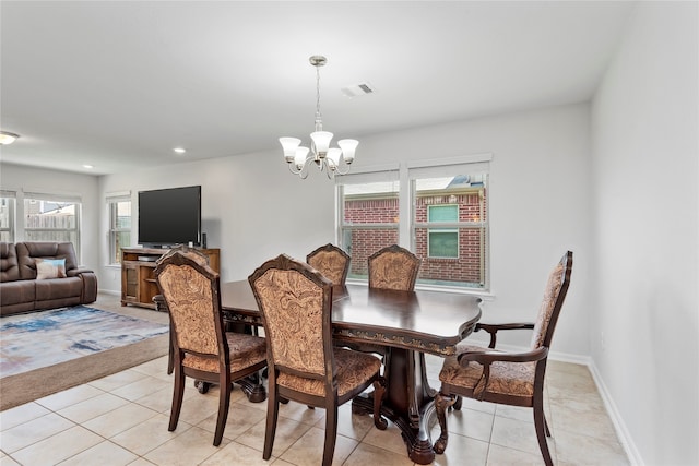 dining area featuring light tile patterned floors and an inviting chandelier