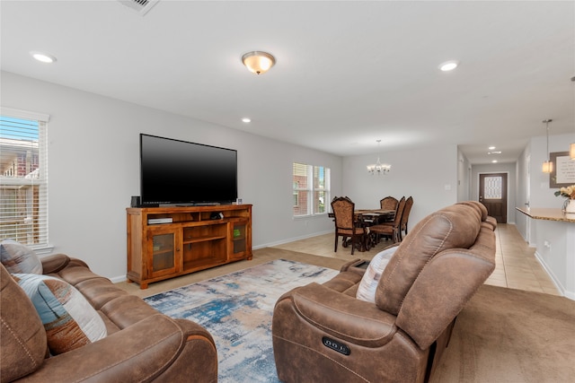 tiled living room featuring plenty of natural light and an inviting chandelier