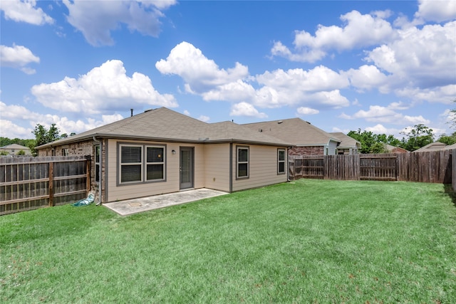 rear view of property featuring a patio and a lawn