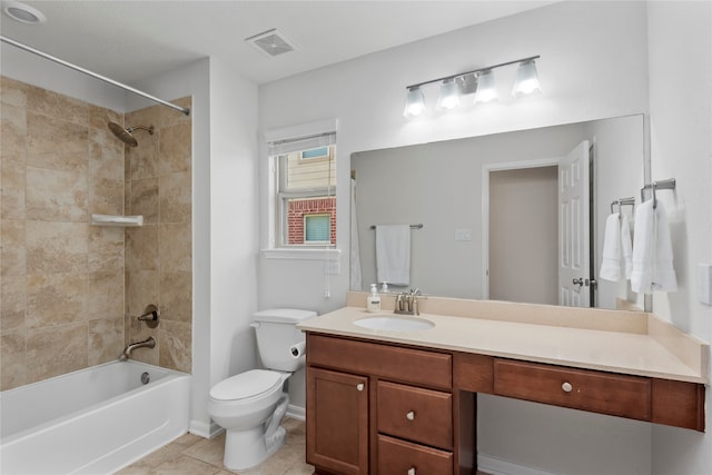 full bathroom featuring tile patterned floors, vanity, tiled shower / bath combo, and toilet