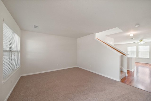 carpeted spare room featuring ceiling fan