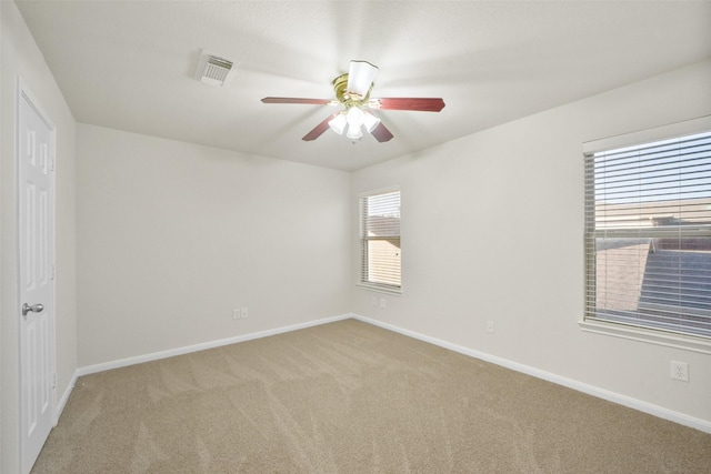 spare room with light colored carpet and ceiling fan