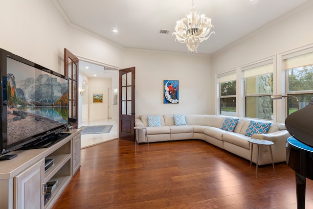 living room with crown molding, dark wood-type flooring, and a chandelier