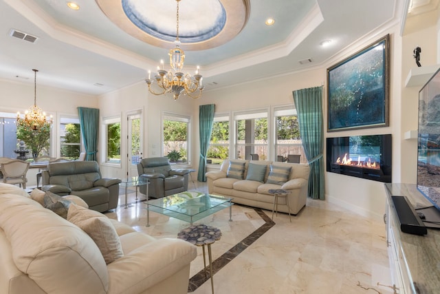 living room featuring a chandelier, a tray ceiling, and crown molding