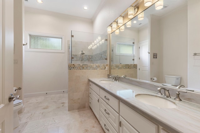 bathroom featuring a tile shower, crown molding, vanity, and toilet