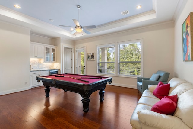 recreation room with ornamental molding, a raised ceiling, ceiling fan, dark wood-type flooring, and pool table