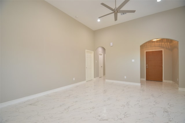 empty room featuring high vaulted ceiling and ceiling fan