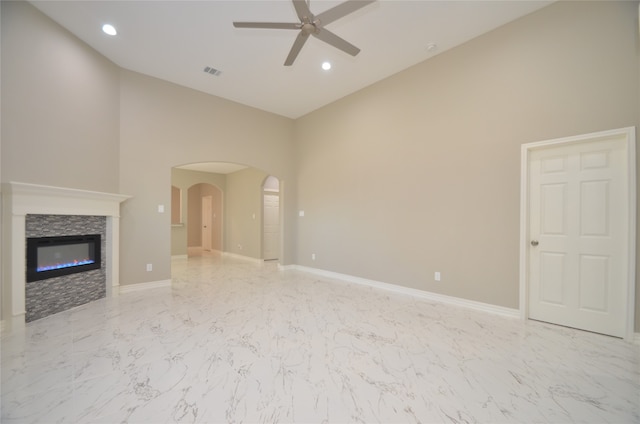 unfurnished living room with ceiling fan, a fireplace, and high vaulted ceiling