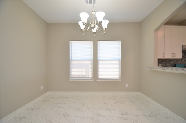 unfurnished dining area featuring an inviting chandelier